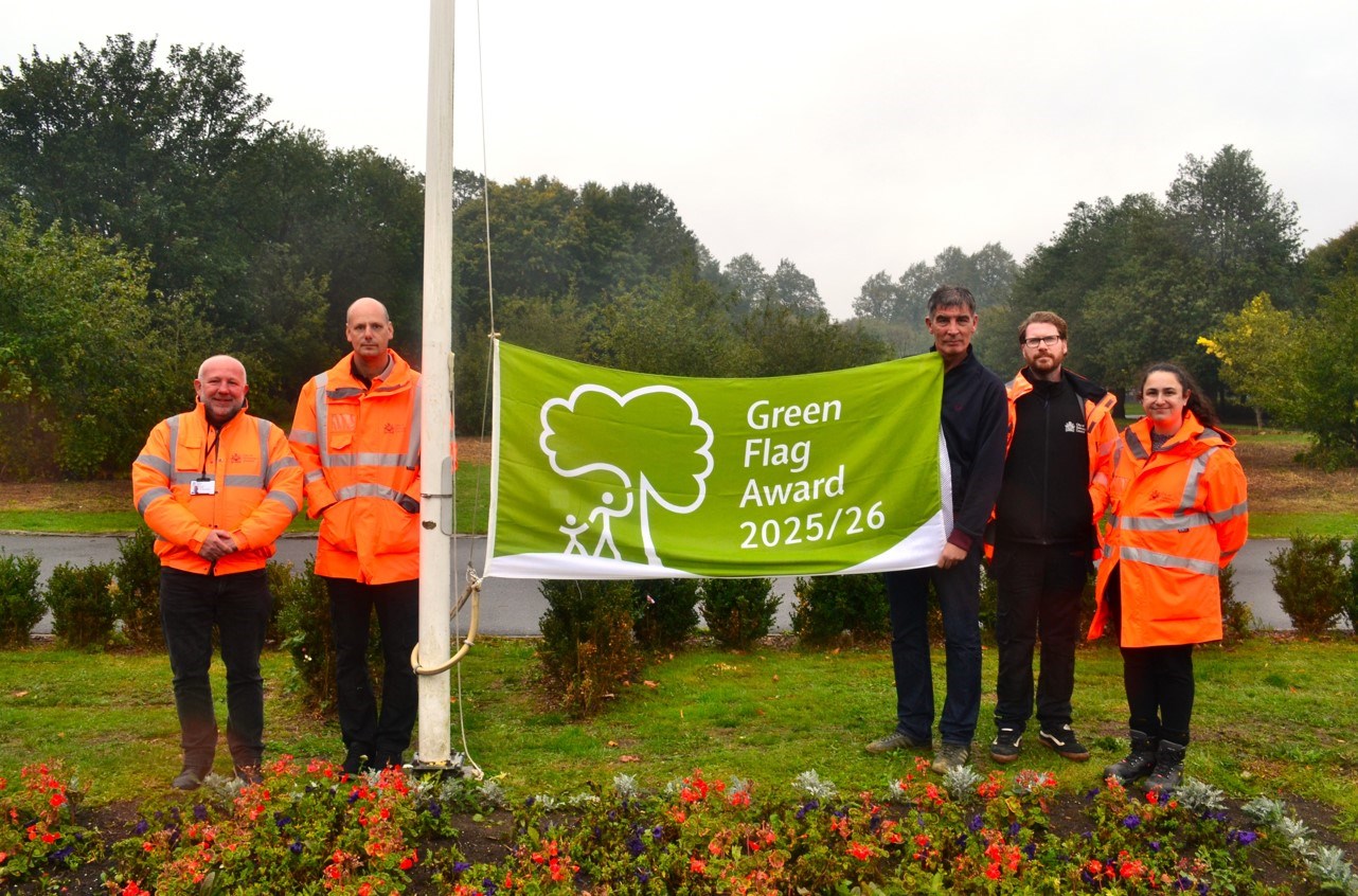 People standing by the Green Flag for Bentley Park
